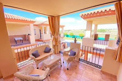 a balcony with chairs and a table on a balcony at Apartamento Camaleón in Chipiona