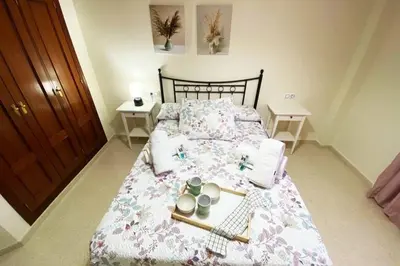 a bedroom with a bed with a tray of food on it at Apartamento Camaleón in Chipiona