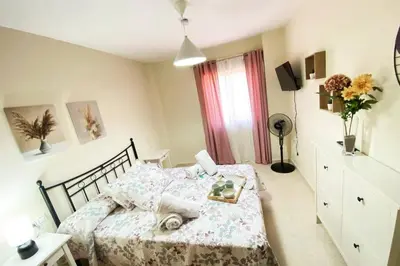 a bedroom with a bed and a table and a window at Apartamento Camaleón in Chipiona