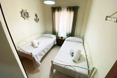 two beds in a room with a window at Apartamento Camaleón in Chipiona