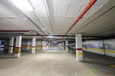 an empty parking garage with white and yellow columns at Lightbooking América I Sanlúcar de Barrameda in Sanlúcar de Barrameda