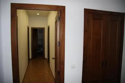 a hallway with two wooden doors and a hallwayngth at Moderno y amplio chalet, con piscina privada in Chiclana de la Frontera