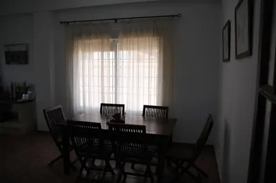 a dining room with a table and chairs and a window at Moderno y amplio chalet, con piscina privada in Chiclana de la Frontera