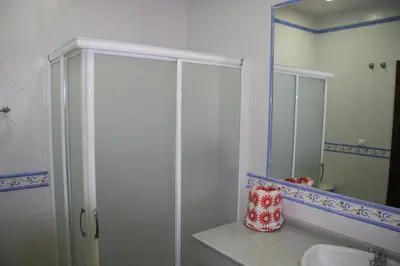 a bathroom with a shower and a sink and a mirror at Moderno y amplio chalet, con piscina privada in Chiclana de la Frontera