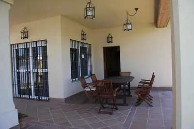a patio with a table and chairs and lights at Moderno y amplio chalet, con piscina privada in Chiclana de la Frontera