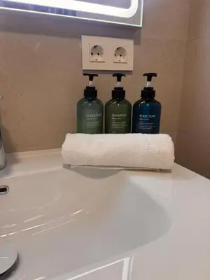 two bottles of soap and a paper towel on a bathroom sink at Apartamento Pinares del atlantico in Chiclana de la Frontera