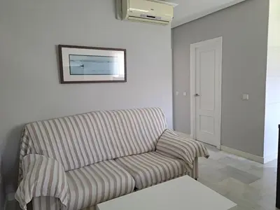 a living room with a couch and a picture on the wall at Apartamento Pinares del atlantico in Chiclana de la Frontera