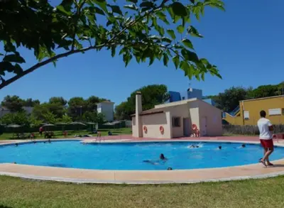 a man standing next to a swimming pool at Apartamento Pinares del atlantico in Chiclana de la Frontera