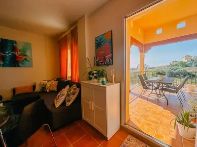 a living room with a couch and a table and a balcony at DeCapi House in Sanlúcar de Barrameda