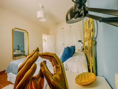 a bedroom with a bed with a gold frame at DeCapi House in Sanlúcar de Barrameda