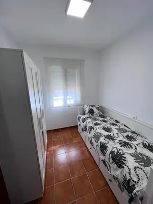 a small bedroom with a bed and a window at Casa de Fernando in Puerto Real
