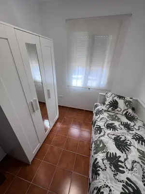 a bedroom with a bed and a tiled floor at Casa de Fernando in Puerto Real