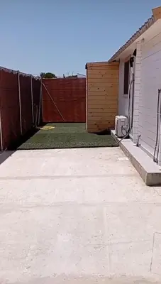 a backyard with a fence and a lawn at Casa de madera muy acogedora en una zona tranquila in Chiclana de la Frontera