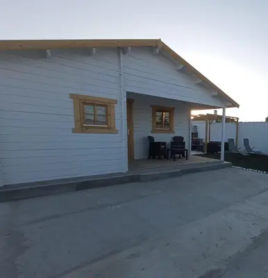 a white house with a porch and a patio at Casa de madera muy acogedora en una zona tranquila in Chiclana de la Frontera
