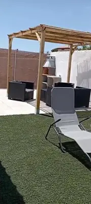 a white chair sitting on top of a green rug at Casa de madera muy acogedora en una zona tranquila in Chiclana de la Frontera