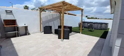 a patio with a gazebo and a grill at Casa de madera muy acogedora en una zona tranquila in Chiclana de la Frontera