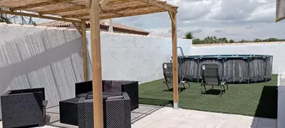 a patio with a gazebo with chairs and a table at Casa de madera muy acogedora en una zona tranquila in Chiclana de la Frontera