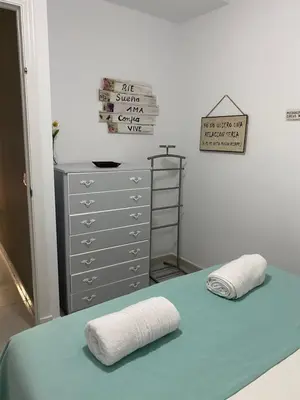 a room with a bed and a dresser with towels at LAS 7 ESQUINAS in El Puerto de Santa María