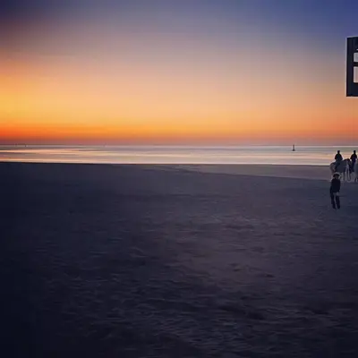 a group of people walking on the beach at sunset at Casa Julia in Sanlúcar de Barrameda