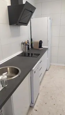 a white kitchen with a sink and a refrigerator at Casa Julia in Sanlúcar de Barrameda