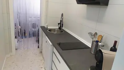 a small kitchen with a sink and a shower at Casa Julia in Sanlúcar de Barrameda