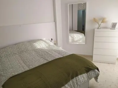 a bedroom with a bed and a dresser and a mirror at Casa Julia in Sanlúcar de Barrameda