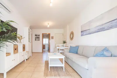 a living room with a couch and a table at Apartamento Planta Baja Coto Sancti Petri Playa de la Barrosa in Chiclana de la Frontera