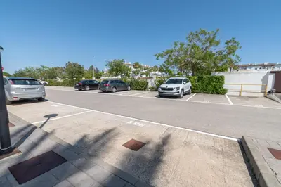 a parking lot with several cars parked in it at Apartamento Planta Baja Coto Sancti Petri Playa de la Barrosa in Chiclana de la Frontera