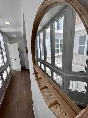 a spiral staircase in a room with windows at GATU PREMIUM Villa Flamenca , Preferente mayores de 25 años y familias in Cádiz