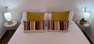 a bed with two pillows on it with two lamps at GATU PREMIUM Villa Flamenca , Preferente mayores de 25 años y familias in Cádiz