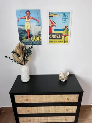 a black dresser with two posters on the wall at GATU PREMIUM Villa Flamenca , Preferente mayores de 25 años y familias in Cádiz