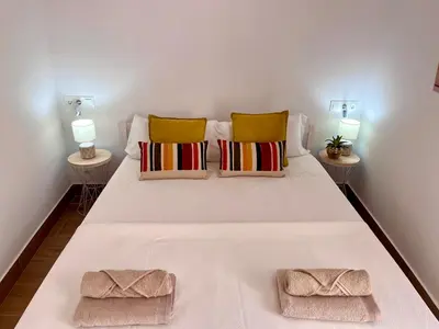 a white bed with two pillows and two lamps at GATU PREMIUM Villa Flamenca , Preferente mayores de 25 años y familias in Cádiz