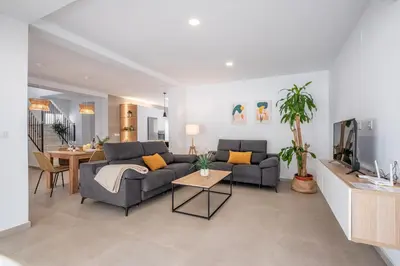 a living room with two couches and a table at Villa Empul La Caracola in Chiclana de la Frontera