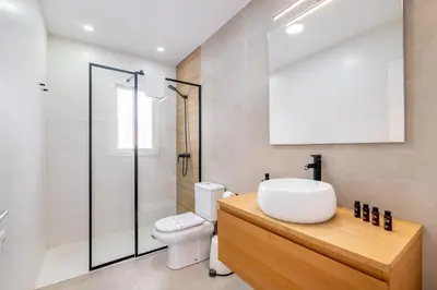 a bathroom with a white sink and a toilet at Villa Empul La Caracola in Chiclana de la Frontera