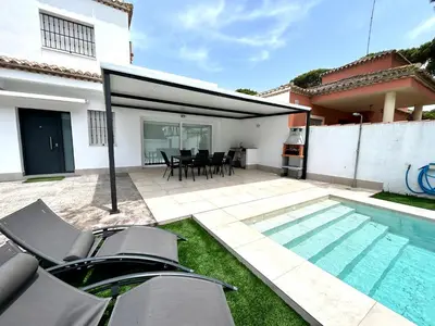 a backyard with a swimming pool and a house at Villa Empul La Caracola in Chiclana de la Frontera