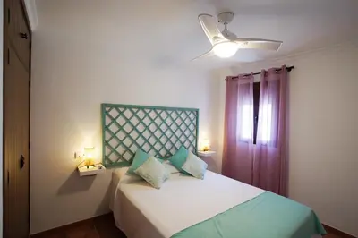 a bedroom with a bed with two pillows and a window at Casa PauMar, tu casa en Arcos de la Frontera in Arcos de la Frontera