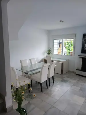 a dining room with a glass table and white chairs at Casa con piscina privada in El Puerto de Santa María