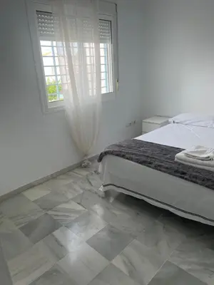a bedroom with a bed and a tiled floor at Casa con piscina privada in El Puerto de Santa María
