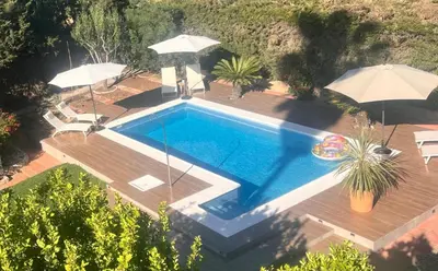 an overhead view of a swimming pool with umbrellas at Arriba stijlvol appartement met zwembad en tuin in Conil de la Frontera