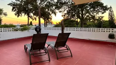 two chairs and a table on a patio at Arriba stijlvol appartement met zwembad en tuin in Conil de la Frontera