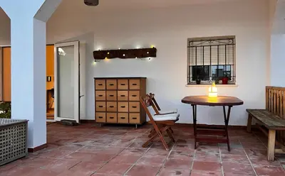 a room with a table and a chair and a table at Arriba stijlvol appartement met zwembad en tuin in Conil de la Frontera