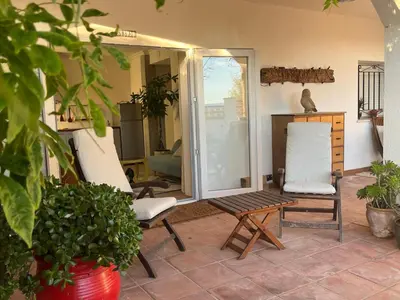 a patio with two chairs and a table at Arriba stijlvol appartement met zwembad en tuin in Conil de la Frontera