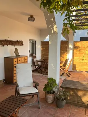 a patio with a chair and a table at Arriba stijlvol appartement met zwembad en tuin in Conil de la Frontera