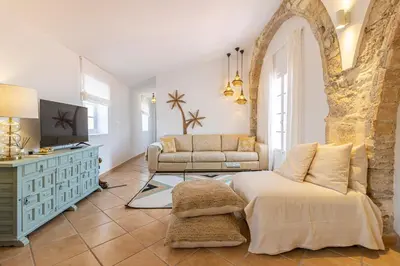 a living room with a bed and a couch at Ático La Casa Rosa - Parking opcional in Jerez de la Frontera