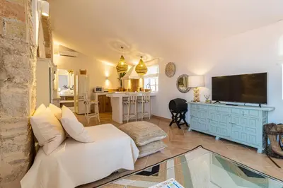a living room with a couch and a television at Ático La Casa Rosa - Parking opcional in Jerez de la Frontera