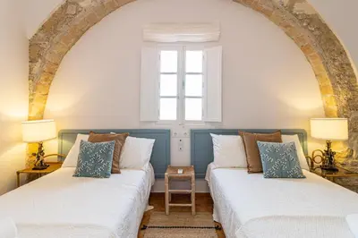 two beds in a room with a window at Ático La Casa Rosa - Parking opcional in Jerez de la Frontera