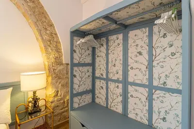 a room with a bed and a wall with wallpaper at Ático La Casa Rosa - Parking opcional in Jerez de la Frontera