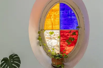 a mirror with a window with a potted plant at Ático La Casa Rosa - Parking opcional in Jerez de la Frontera
