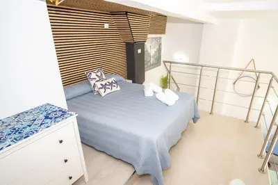 a bedroom with a blue bed with pillows on it at MARÍTIMO28 in Cádiz