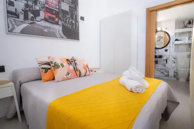 a bedroom with a yellow bed with towels on it at MARÍTIMO28 in Cádiz